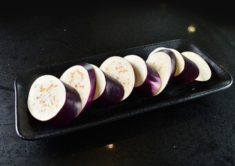 cold mixed raw vegetables,  beancurd, mushroom, carrot, noodle, tofu, lotus, corn in plate for steam boat hot pot ingredient on black marble table asian halal food cuisine menu for restaurant