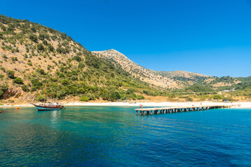  Boat pier at Kakome Beach seen from the boat on the Albanian riviera near Sarande and its turquoise waters, Albania