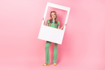 Full body photo of pretty young girl hold instant photo frame wear trendy green print outfit...