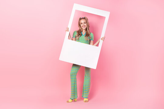 Full body photo of pretty young girl hold instant photo frame wear trendy green print outfit isolated on pink color background