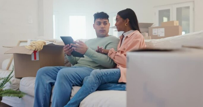 Talking couple on sofa with boxes, tablet or smart home for security, automation or heating in apartment moving. Future technology, man and woman on couch, digital app and online control of new house