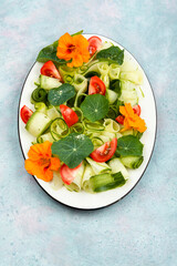 Vegetable salad with nasturtium flowers.