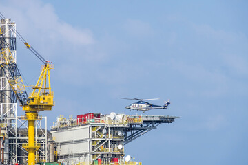 A helicopter landed on an oil production platform for transferring of offshore crew at oil field.