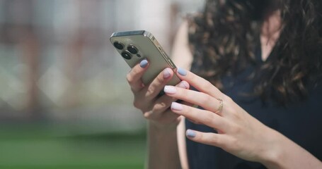 Woman using smartphone 14 pressing finger, reading social media internet, typing text or shopping online, Mobile phone in two hands at home or work close up.