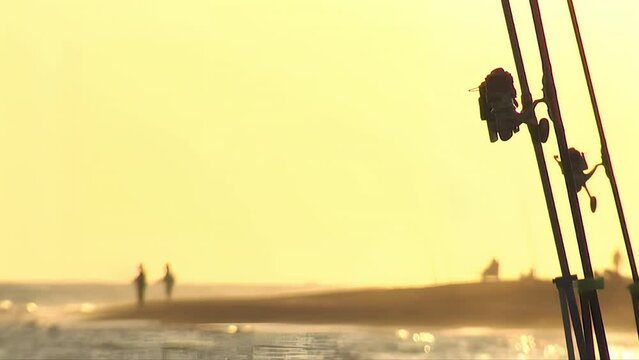 Fishing reels at sunset. Surfcasting