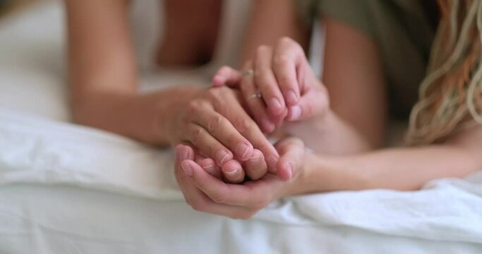 homosexual couple in bed, love and tenderness, holding hands, lesbian couple together Indoors 