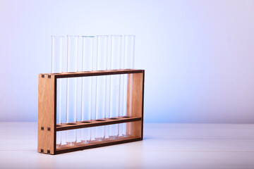 Empty glass test tubes on a wooden stand on the table. Empty glass tubes for testing in the laboratory