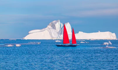 Papier Peint photo Antarctique Giant iceberg near Kulusuk with lone yacht with red sails - Greenland, East Greenland
