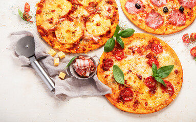 Different types of italian pizza on light background.
