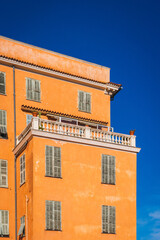 orange European style building facade against blue sky background
