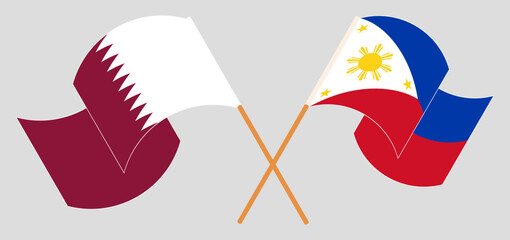 Crossed and waving flags of Qatar and the Philippines