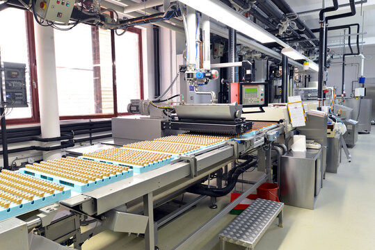 Production of pralines in a factory for the food industry - automatic conveyor belt with chocolate