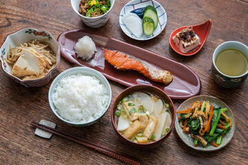 焼き鮭の家庭的な和定食（ごはん・大根とお揚げとネギの味噌汁・納豆・漬物・冷奴・厚揚げともやしの煮物・小松菜と人参と揚げの炒め煮）