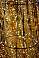 Garlands on a metal frame on a background of yellow shiny fabric