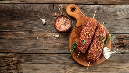 raw Lula kebab on skewers with spices, on a wooden background, Concept healthy and balanced eating. place for text, top view