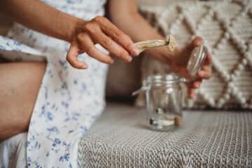 Woman taking psychedelic mushroom out of jar
