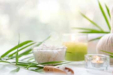 Thai Spa Treatments aroma therapy salt and  sugar scrub massage with bamboo leaves with candle, white background. Thailand. Healthy Concept