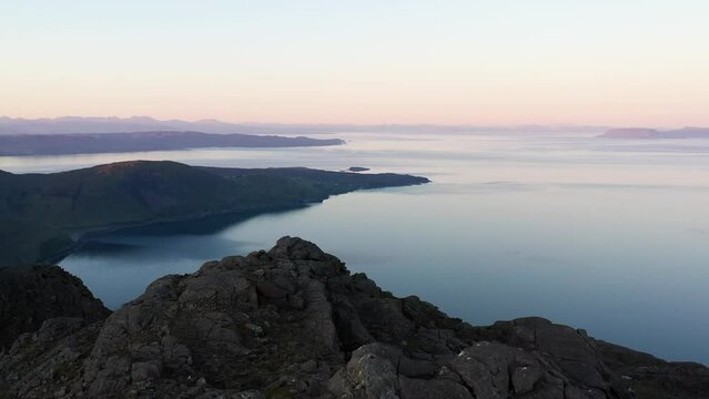 Aerial view of the Jagged Mountains, Lochs and Sea on the Isle of Skye, Scotland UK at Sunrise with Colourful Skies. Hiking and camping in the Cuillin Mountains. 