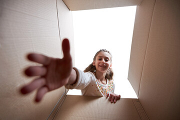 kid reaching for something in the box with smile