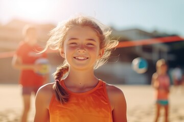 Portrait of smiling little girl playing beach volleyball on sunny summer day