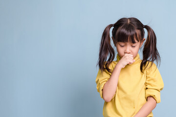 A little girl is coughing, sick, has a fever.