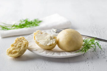 Freshly baked yeast-free steamed buns served with butter and herbs on a light blue background