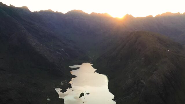 Aerial view of the Jagged Mountains, Lochs and Sea on the Isle of Skye, Scotland UK at Sunset with Colourful Skies. Hiking and camping in the Cuillin Mountains. 