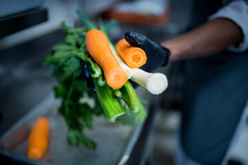 légumes tenus par un cuisinier avec gants