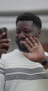 Smiling man having video call via smart phone outdoors