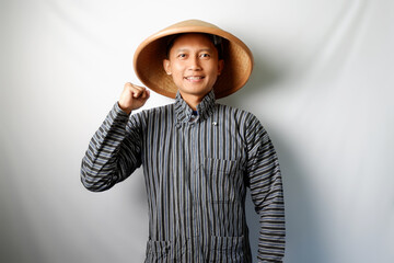 Happy Asian farmer standing and looking at camere with clenched fist isolated on white background