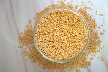 A bowl of Unpolished yellow pigeon peas or Toor dal in Blur Background