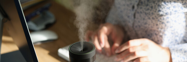 Modern air humidifier device on office desktop close-up.