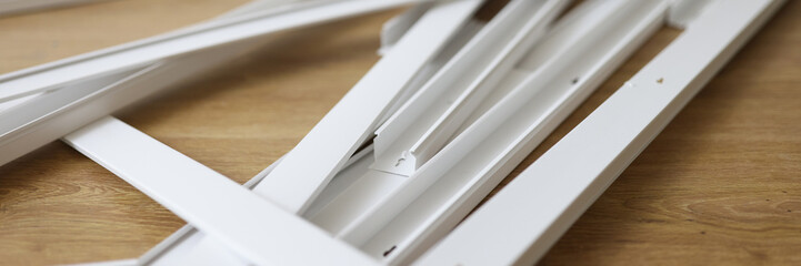 Lots of white plastic cable trays on the wooden floor.