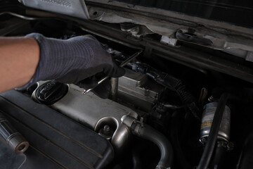Fototapeta na wymiar Mechanic man hand repair ignition on car engine
