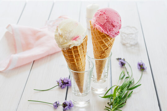 A variety of balls of ice cream in cones with chocolate, vanilla and strawberries. Scenery for marine theme