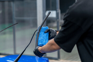 man wipes the car, car wipers at the car wash