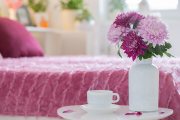 Fototapeta na wymiar hot drink in white cup on background pink and white bedroom