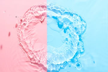 Papier Peint photo Lavable Cristaux Water pink blue surface abstract background. Waves and ripples texture of cosmetic aqua moisturizer with bubbles.