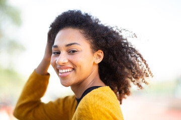 Close up happy young woman laughing with hand in hair