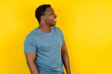 Young handsome man standing over yellow studio background very happy and excited about new plans.