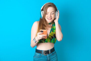 Happy Young beautiful woman wearing top feels good while focused in screen of smartphone. People, technology, lifestyle © Jihan