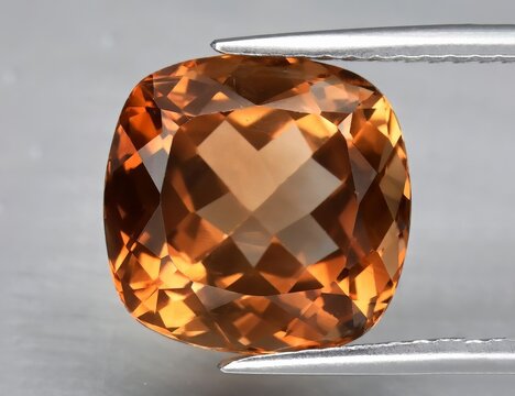 Natural gemstone orange topaz on a gray background. Imperial topaz, champagne topaz
