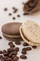 French creamy macaroons in white and brown tone on white background, coffee beans and macarons. Macro