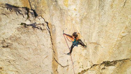 AERIAL, CLOSE UP Climber clips in belay rope before climbing a difficult section - obrazy, fototapety, plakaty