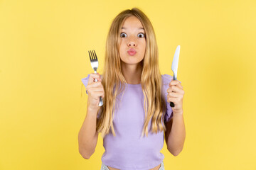 hungry Beautiful caucasian kid girl wearing violet dress holding in hand fork knife want tasty yummy pizza pie