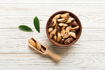 Fresh healthy Brazil nuts in bowl on colored table background. Top view Healthy eating bertholletia concept. Super foods