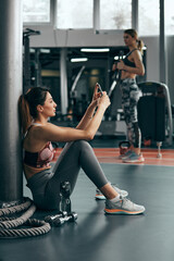 Sporty lady making pause in a gym after exercise.