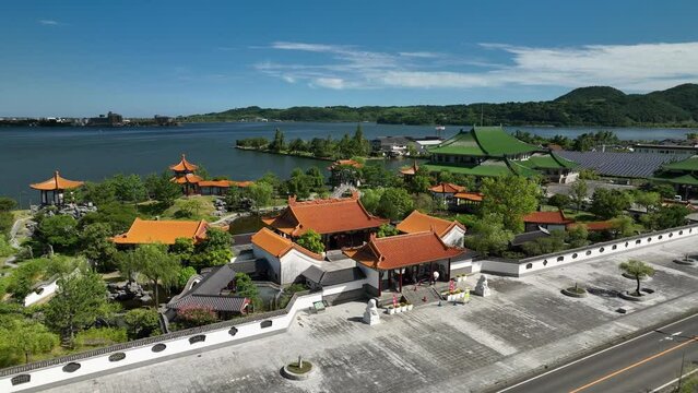 Aerial view of traditional Japanese buildings by lake on sunny day