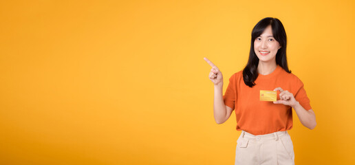 Vibrant young lady confidently displaying a credit card, signifying seamless online payment...