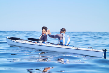 Water, man and woman in kayak with high five on lake, beach or river in sports challenge on...